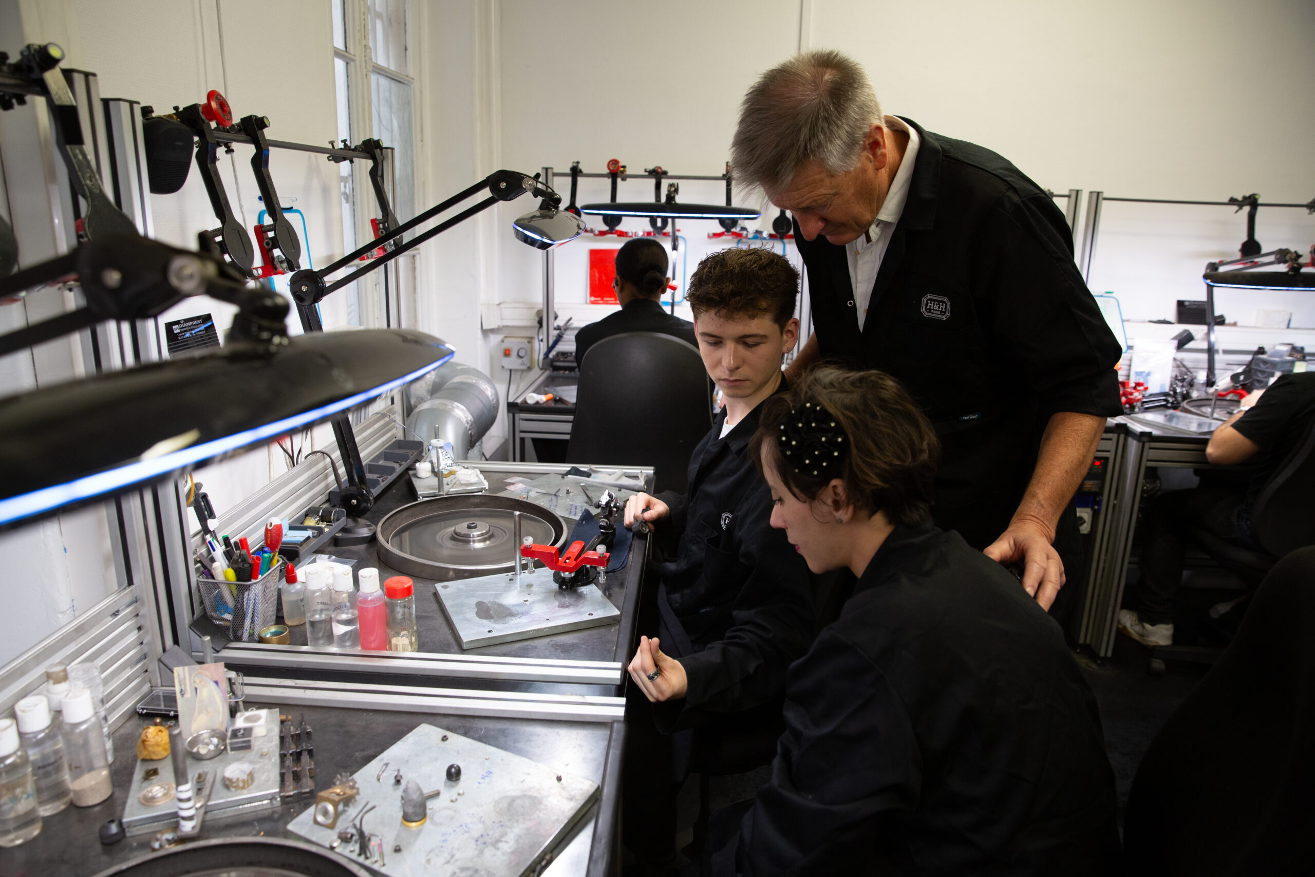 Maître Tailleur transmettant le geste à deux apprentis, école de formation H&H