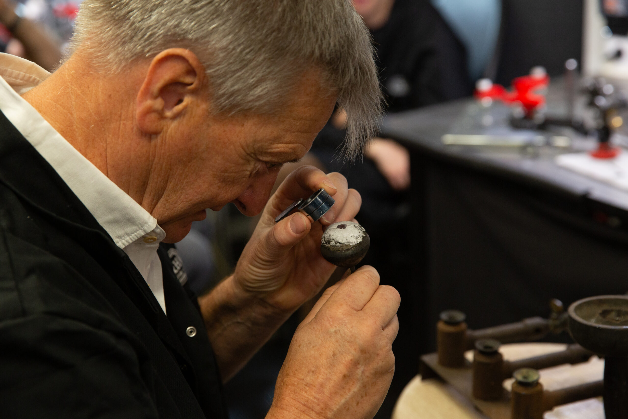 Ma&icirc;tre Tailleur H&H examinant &agrave; la loupe une pierre de centre, atelier Paris 9e